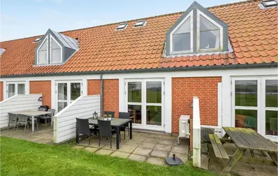 a house with a patio with a table and chairs at Gorgeous Apartment In Lemvig in Lemvig