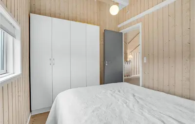 a bedroom with a white bed and wooden walls at Stunning Home In Vinderup With Sauna in Vinderup