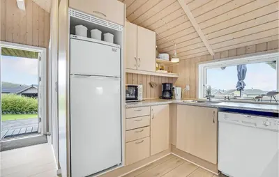 a kitchen with a white refrigerator and a window at Stunning Home In Vinderup With Sauna in Vinderup