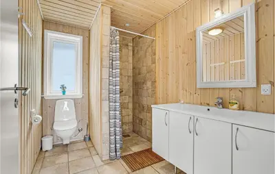 a bathroom with a toilet and a sink and a window at 7 Bedroom Gorgeous Home In Vinderup in Vinderup