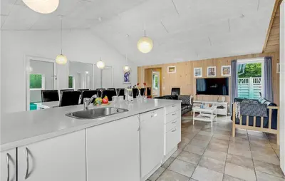 a kitchen with a sink and a living room at 7 Bedroom Gorgeous Home In Vinderup in Vinderup