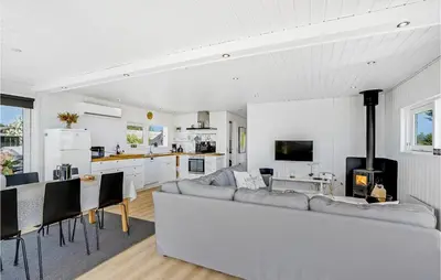a living room with a couch and a kitchen at Awesome Home In Øster Assels With Sauna in Øster Assels