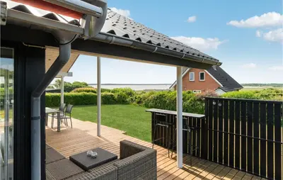 a pergola on a deck with a table and chairs at Awesome Home In Øster Assels With Sauna in Øster Assels