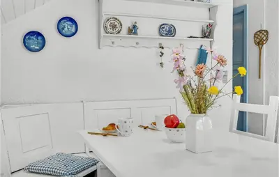 a white counter with blue plates and a vase with flowers at 3 Bedroom Nice Home In Hurup Thy in Sønder Ydby