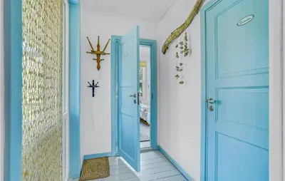 a hallway with blue doors and a tile floor at 3 Bedroom Nice Home In Hurup Thy in Sønder Ydby
