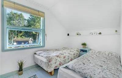 two beds in a room with a window at 3 Bedroom Nice Home In Hurup Thy in Sønder Ydby