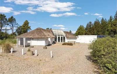 a building with a thatched roof and a gravel driveway at 4 Bedroom Lovely Home In Fjerritslev in Fjerritslev