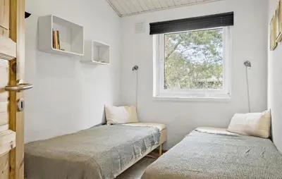 two beds in a small room with a window at Cozy Home In Fjerritslev With Wifi in Fjerritslev