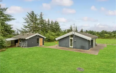 two green buildings in a field with grass at 3 Bedroom Beautiful Home In Frøstrup in Frøstrup