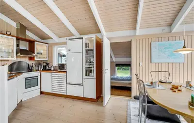 a kitchen with a white refrigerator and a table at 3 Bedroom Beautiful Home In Frøstrup in Frøstrup
