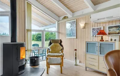 a living room with a chair and a balcony at 3 Bedroom Beautiful Home In Frøstrup in Frøstrup
