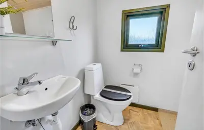 a white bathroom with a toilet and a sink at Lovely Home In Hanstholm With Wifi in Hanstholm