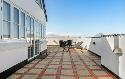 a balcony with a table and chairs on a building at Beautiful Home In Frøstrup With Sauna in Frøstrup