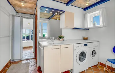 a kitchen with a washing machine and a sink at Beautiful Home In Frøstrup With Sauna in Frøstrup