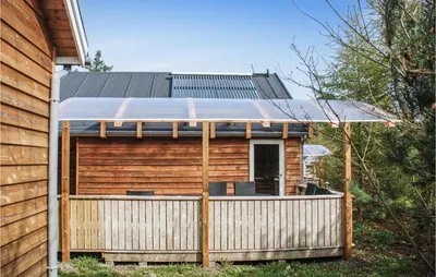 a wooden cabin with an awning on a deck at 2 Bedroom Nice Home In Hanstholm in Hanstholm