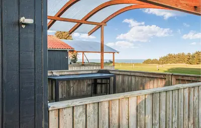 an external view of a wooden fence with an archway at Stunning Home In Hanstholm With Kitchen in Hanstholm