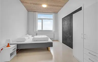 a white bedroom with a bed and a window at Stunning Home In Hanstholm With Sauna in Hanstholm