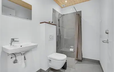 a bathroom with a toilet and a sink and a shower at Stunning Home In Hanstholm With Sauna in Hanstholm