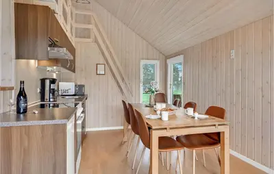a kitchen and dining room with a wooden table and chairs at Stunning Home In Hanstholm With Wifi in Hanstholm