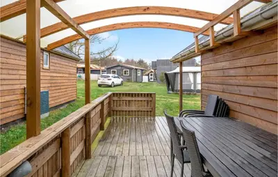 a wooden deck with chairs and a pergola at Stunning Home In Hanstholm With Wifi in Hanstholm