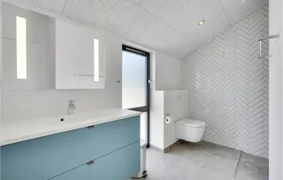 a bathroom with a white sink and a toilet at Nice Home In Blokhus With Wifi in Blokhus