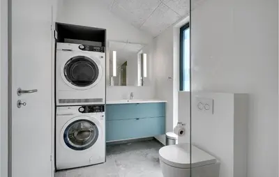 a bathroom with a washing machine and a sink at Nice Home In Blokhus With Wifi in Blokhus