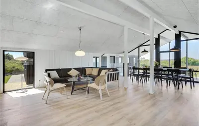 a living room with a couch and tables and chairs at Nice Home In Blokhus With Wifi in Blokhus