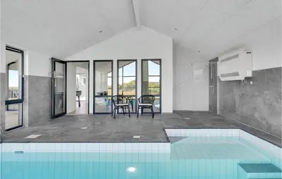 a house with a swimming pool and a table and chairs at Nice Home In Blokhus With Wifi in Blokhus