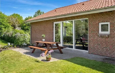 a picnic table in front of a brick house at Pet Friendly Home In Farsø With Sauna in Farsø