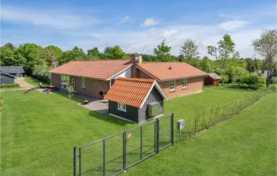 a small house with an orange roof on a yard at Pet Friendly Home In Farsø With Sauna in Farsø