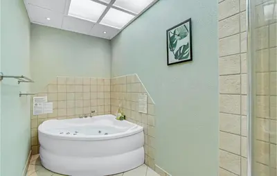 a bathroom with a large white tub in a room at Cozy Home In Farsø With Sauna in Farsø