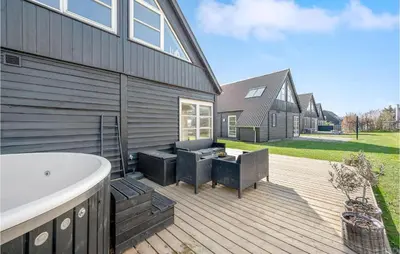 a deck with a bath tub next to a house at 3 Bedroom Beautiful Home In Farsø in Farsø