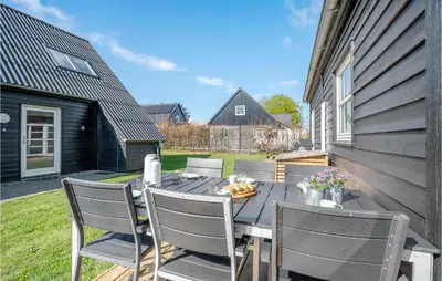 a patio with a table with chairs and bananas on it at 3 Bedroom Beautiful Home In Farsø in Farsø