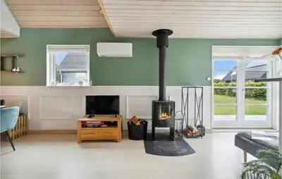 a fireplace in a living room with green walls at 3 Bedroom Beautiful Home In Farsø in Farsø