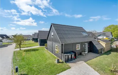 a house with a black roof on a yard at 3 Bedroom Beautiful Home In Farsø in Farsø