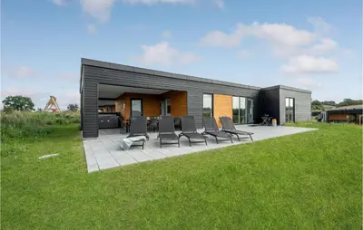 a group of chairs sitting on a patio in front of a house at 4 Bedroom Stunning Home In Løgstrup in Løgstrup