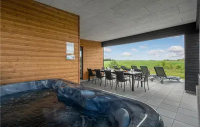 a tub in the middle of a patio with a table and chairs at 4 Bedroom Stunning Home In Løgstrup in Løgstrup