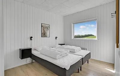 a bedroom with a bed with white sheets and a window at Beautiful Home In Løgstrup With Kitchen in Løgstrup