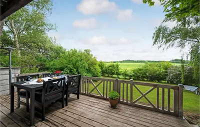 a wooden deck with a table and chairs on it at Beautiful Home In Løgstrup With Wifi in Løgstrup
