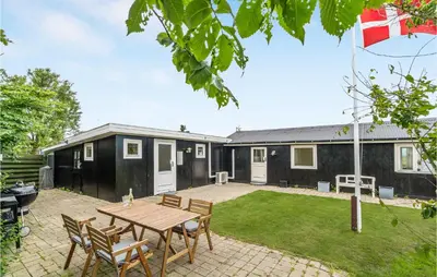 a backyard with a table and chairs and a house at 1 Bedroom Beautiful Home In Løgstør in Løgstør