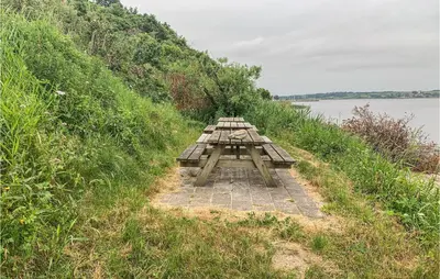 a picnic table on a hill next to a lake at Cozy Home In Løgstrup With Kitchen in Løgstrup
