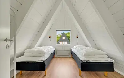 a room with two beds in a attic at 2 Bedroom Cozy Home In Farsø in Farsø