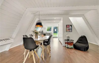 a dining room with a table and black chairs at 2 Bedroom Cozy Home In Farsø in Farsø