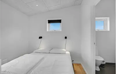 a white bed in a white room with a toilet at 4 Bedroom Gorgeous Home In Løgstrup in Løgstrup