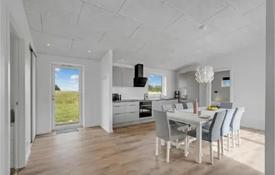 a white kitchen and dining room with a table and chairs at 4 Bedroom Gorgeous Home In Løgstrup in Løgstrup