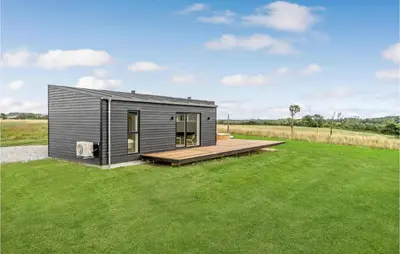 a small gray tiny house on a grass field at 4 Bedroom Gorgeous Home In Løgstrup in Løgstrup