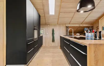a kitchen with black cabinets and a black refrigerator at 3 Bedroom Cozy Home In Nibe in Nibe