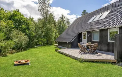 a backyard with a wooden deck with a table and chairs at 3 Bedroom Cozy Home In Højslev in Højslev