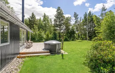 a backyard with a hot tub on a wooden deck at 3 Bedroom Cozy Home In Højslev in Højslev