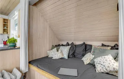 a couch in a tiny house with a window at 3 Bedroom Cozy Home In Højslev in Højslev